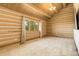 An empty log walled bedroom featuring carpeted floors and a window at 51 West Ranch Trl, Morrison, CO 80465