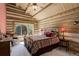 Rustic log cabin bedroom with vaulted ceiling, large window, and southwestern-style bedding at 51 West Ranch Trl, Morrison, CO 80465