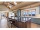 Spacious kitchen features a large island with granite countertop, natural light, and mountain views at 51 West Ranch Trl, Morrison, CO 80465
