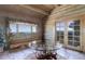 Charming sunroom with log walls, stone floors, large windows, and breathtaking mountain views at 51 West Ranch Trl, Morrison, CO 80465