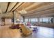 Inviting living room with stone fireplace, wooden beams, and expansive windows showcasing the view at 51 West Ranch Trl, Morrison, CO 80465