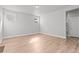 A neutral bedroom with wood floors, large window and access to another room at 21204 E 63Rd Dr, Aurora, CO 80019