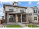 Attractive two-story house with brick detailing, large windows, a yellow door, and professional landscaping at 21204 E 63Rd Dr, Aurora, CO 80019