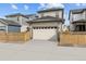 Exterior elevation featuring a two-car garage, ample parking, and privacy fence at 21204 E 63Rd Dr, Aurora, CO 80019