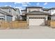 Exterior elevation featuring a two-car garage, ample parking, and privacy fence at 21204 E 63Rd Dr, Aurora, CO 80019