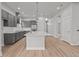 Bright, open kitchen with a large island, gray cabinets, stainless steel appliances and wood floors at 21204 E 63Rd Dr, Aurora, CO 80019