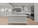 Bright kitchen with a large island, gray cabinets, stainless steel appliances, and hardwood floors at 21204 E 63Rd Dr, Aurora, CO 80019
