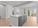 Open concept kitchen with stainless steel appliances, large island, and gray cabinets; seamless flow at 21204 E 63Rd Dr, Aurora, CO 80019