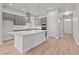Well-lit kitchen featuring a large island, gray cabinets, stainless steel appliances and access to a door at 21204 E 63Rd Dr, Aurora, CO 80019