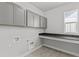 Laundry room features modern gray cabinets, countertops, and utility sink at 21204 E 63Rd Dr, Aurora, CO 80019