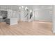 Open-concept living space with wood flooring, modern staircase, and a view into the kitchen area at 21204 E 63Rd Dr, Aurora, CO 80019