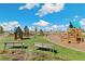 Community playground with playhouses, swings, and climbing structures, ideal for Gathering fun and outdoor activities at 21204 E 63Rd Dr, Aurora, CO 80019
