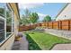 Well-maintained backyard with lush lawn, gravel pathway, and charming landscaping features at 19677 E Vassar Dr, Aurora, CO 80013