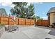 Spacious concrete backyard with a wooden fence and outdoor dining area, perfect for entertaining at 19677 E Vassar Dr, Aurora, CO 80013