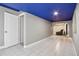 The basement has an open layout, tiled flooring, and an archway leading to a room with seating at 19677 E Vassar Dr, Aurora, CO 80013