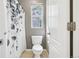 Cozy bathroom featuring a toilet, a patterned shower curtain, a window, and white door at 19677 E Vassar Dr, Aurora, CO 80013