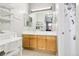 Bathroom with a vanity, sink, open shelves, and mirrors reflecting another room at 19677 E Vassar Dr, Aurora, CO 80013