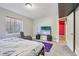 Bright bedroom with a large TV, comfortable chair, and natural light from the window at 19677 E Vassar Dr, Aurora, CO 80013
