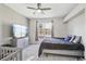 Bright bedroom featuring a ceiling fan, dresser with TV, and a window providing natural light at 19677 E Vassar Dr, Aurora, CO 80013