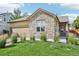 Charming home with a stone facade, well-manicured lawn, and an attached two-car garage at 19677 E Vassar Dr, Aurora, CO 80013