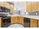 Modern kitchen area featuring wood cabinets, stainless appliances, and a view to the dining room at 19677 E Vassar Dr, Aurora, CO 80013