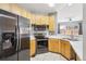 Well-equipped kitchen with wooden cabinets, stainless steel appliances, and tiled flooring at 19677 E Vassar Dr, Aurora, CO 80013