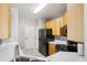 Functional kitchen with light wood cabinetry, modern appliances, and tiled floors at 19677 E Vassar Dr, Aurora, CO 80013