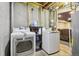 Functional laundry area with a modern washer, dryer, and convenient storage solutions at 19677 E Vassar Dr, Aurora, CO 80013