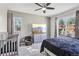 Serene bedroom with a crib, a large window, soft carpeting, and a ceiling fan at 19677 E Vassar Dr, Aurora, CO 80013