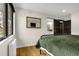 Bright bedroom featuring hardwood floors, a dark sliding door, and a stylish mirror on the wall at 597 Vista Dr, Castle Rock, CO 80104