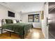 Cozy bedroom with a black metal bed frame, hardwood floors, and a window overlooking a quiet street at 597 Vista Dr, Castle Rock, CO 80104