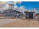 Contemporary home with a detached garage, wide driveway, and unique fence in a serene neighborhood at 597 Vista Dr, Castle Rock, CO 80104