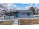 Charming single-story home with a blue door, stone pathway, and a well-manicured lawn in a quiet neighborhood at 597 Vista Dr, Castle Rock, CO 80104