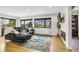 Cozy living room with hardwood floors, large windows, and a comfortable black leather sectional sofa at 597 Vista Dr, Castle Rock, CO 80104