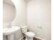 Bathroom features a pedestal sink and a round mirror at 6581 N Malaya St, Aurora, CO 80019