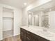 Bathroom features double sinks, dark cabinets, and walk in closet at 6581 N Malaya St, Aurora, CO 80019