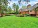 Lush backyard with mature trees, landscaping, and unique architectural details for outdoor enjoyment at 12135 W Applewood Knolls Dr, Lakewood, CO 80215