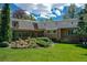 Expansive backyard featuring lush landscaping, a covered patio, and mature trees at 12135 W Applewood Knolls Dr, Lakewood, CO 80215