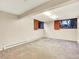 Spacious basement with natural light and neutral carpet, perfect for customization at 12135 W Applewood Knolls Dr, Lakewood, CO 80215