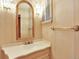 Charming bathroom features a vanity with an oval sink, and an arched mirror with decorative sconces at 12135 W Applewood Knolls Dr, Lakewood, CO 80215