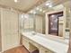 Bathroom with long vanity, large mirror, and linen cabinet, providing ample storage at 12135 W Applewood Knolls Dr, Lakewood, CO 80215