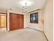 Neutral bedroom with double closet, large window, and classic chandelier at 12135 W Applewood Knolls Dr, Lakewood, CO 80215