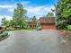 Wide shot of the house exterior with a circular driveway and well-maintained landscaping at 12135 W Applewood Knolls Dr, Lakewood, CO 80215