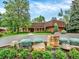 Well-manicured exterior elevation featuring a brick facade, mature trees, and manicured lawn at 12135 W Applewood Knolls Dr, Lakewood, CO 80215