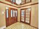 The foyer has tile floors, a chandelier and glass paneled interior and exterior doors at 12135 W Applewood Knolls Dr, Lakewood, CO 80215