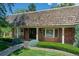 Charming home featuring a wood-shingled roof, brick accents, and a well-manicured front yard at 12135 W Applewood Knolls Dr, Lakewood, CO 80215