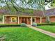 Charming front entrance with a covered porch, brick accents, and manicured lawn at 12135 W Applewood Knolls Dr, Lakewood, CO 80215