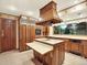 Traditional kitchen featuring wood cabinetry, an island cooktop, and sleek appliances at 12135 W Applewood Knolls Dr, Lakewood, CO 80215