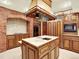 Spacious kitchen with a center island, brick oven surround, and custom wood cabinets at 12135 W Applewood Knolls Dr, Lakewood, CO 80215