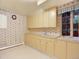 Well-lit laundry room features upper and lower cabinets, a sink, and a window providing natural light at 12135 W Applewood Knolls Dr, Lakewood, CO 80215